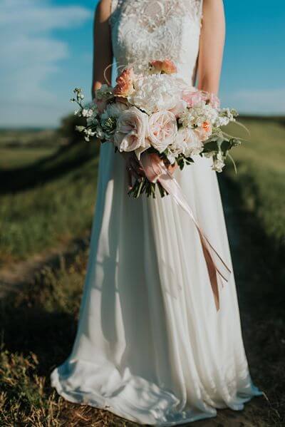 image of Lady in wedding dress with flower bouquet in her hands
